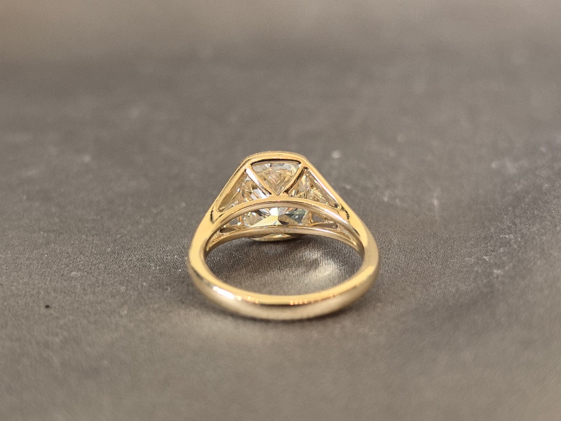 4-carat cushion cut, with emerald side stones on both sides, bezel setting, vintage design