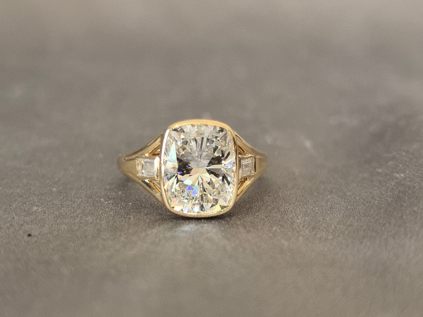 4-carat cushion cut, with emerald side stones on both sides, bezel setting, vintage design