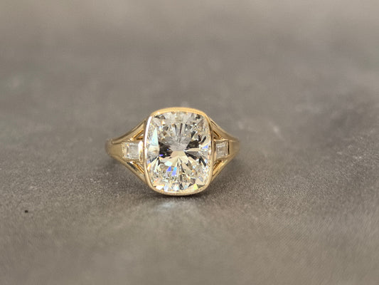 4-carat cushion cut, with emerald side stones on both sides, bezel setting, vintage design
