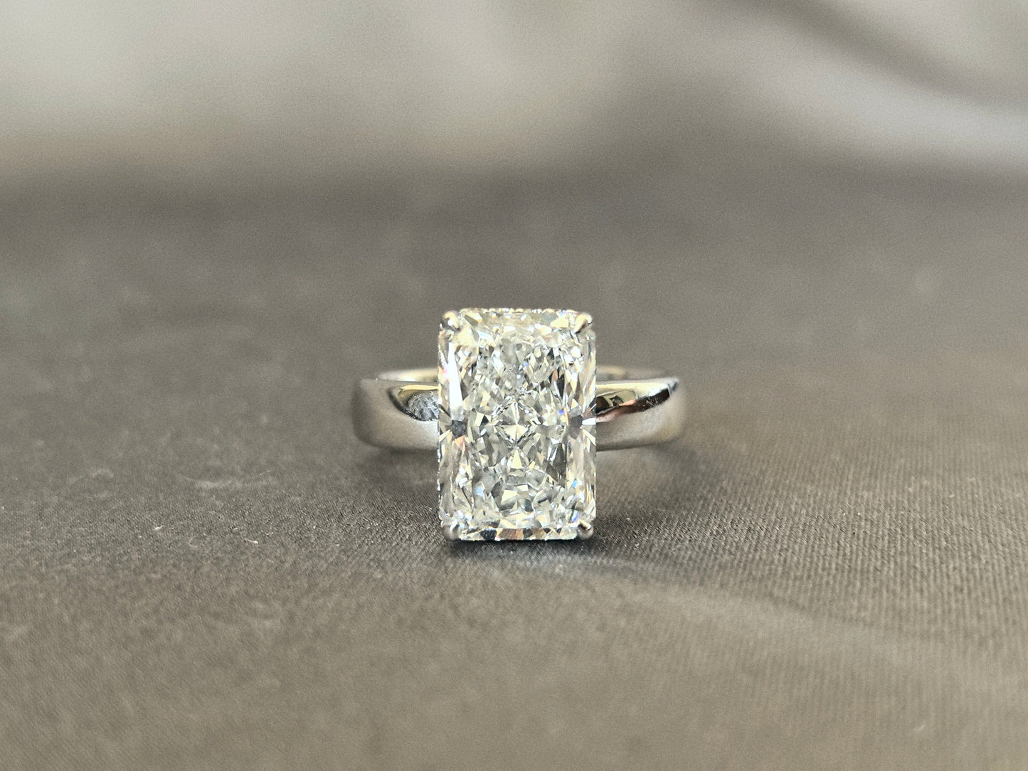 Radiant cut - set with a circle of small diamonds - extra-wide ring band