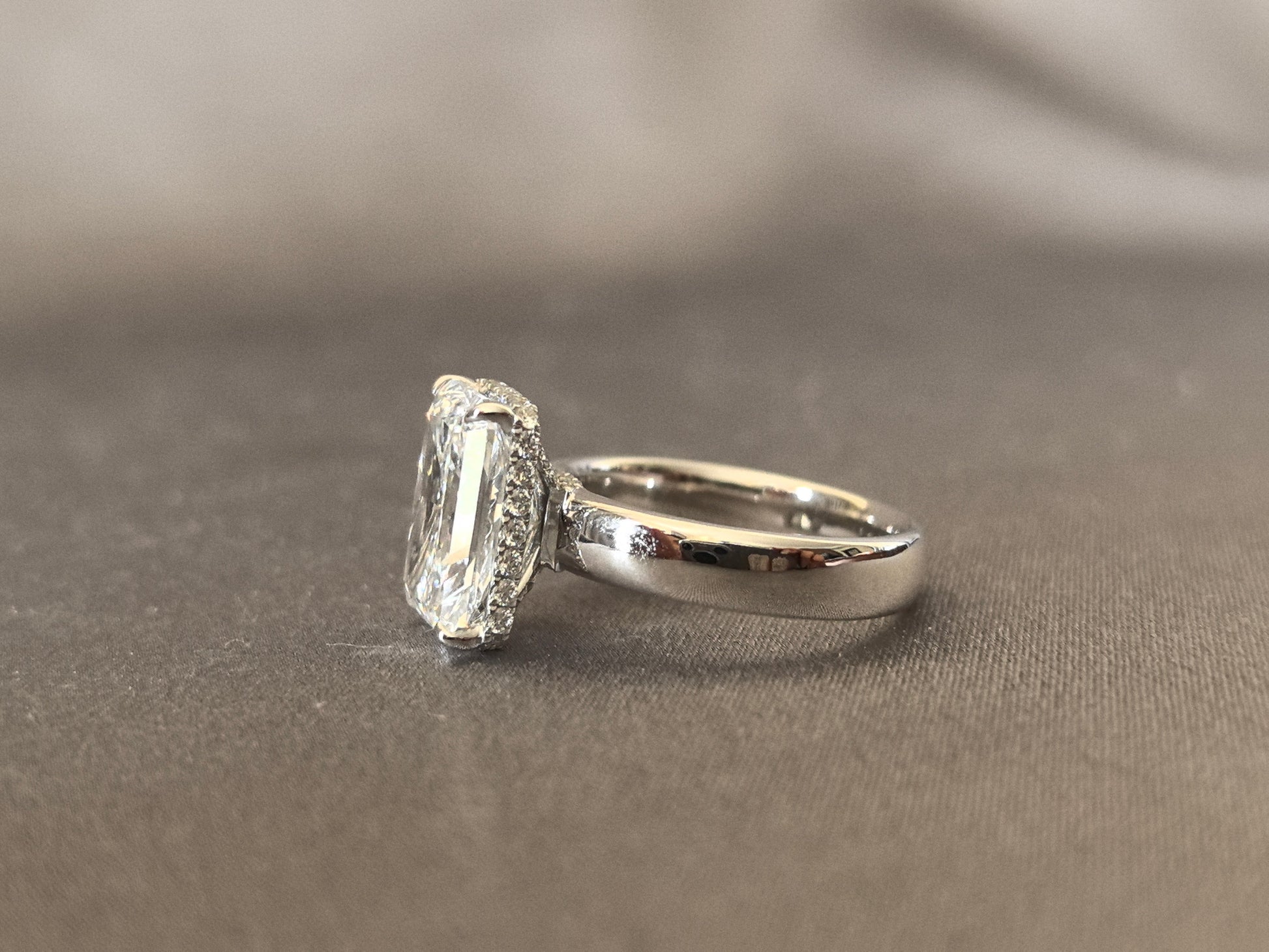 Radiant cut - set with a circle of small diamonds - extra-wide ring band
