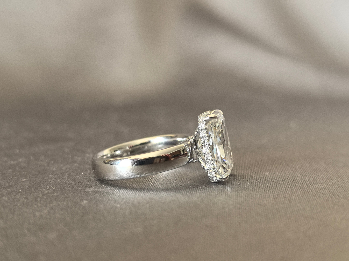 Radiant cut - set with a circle of small diamonds - extra-wide ring band