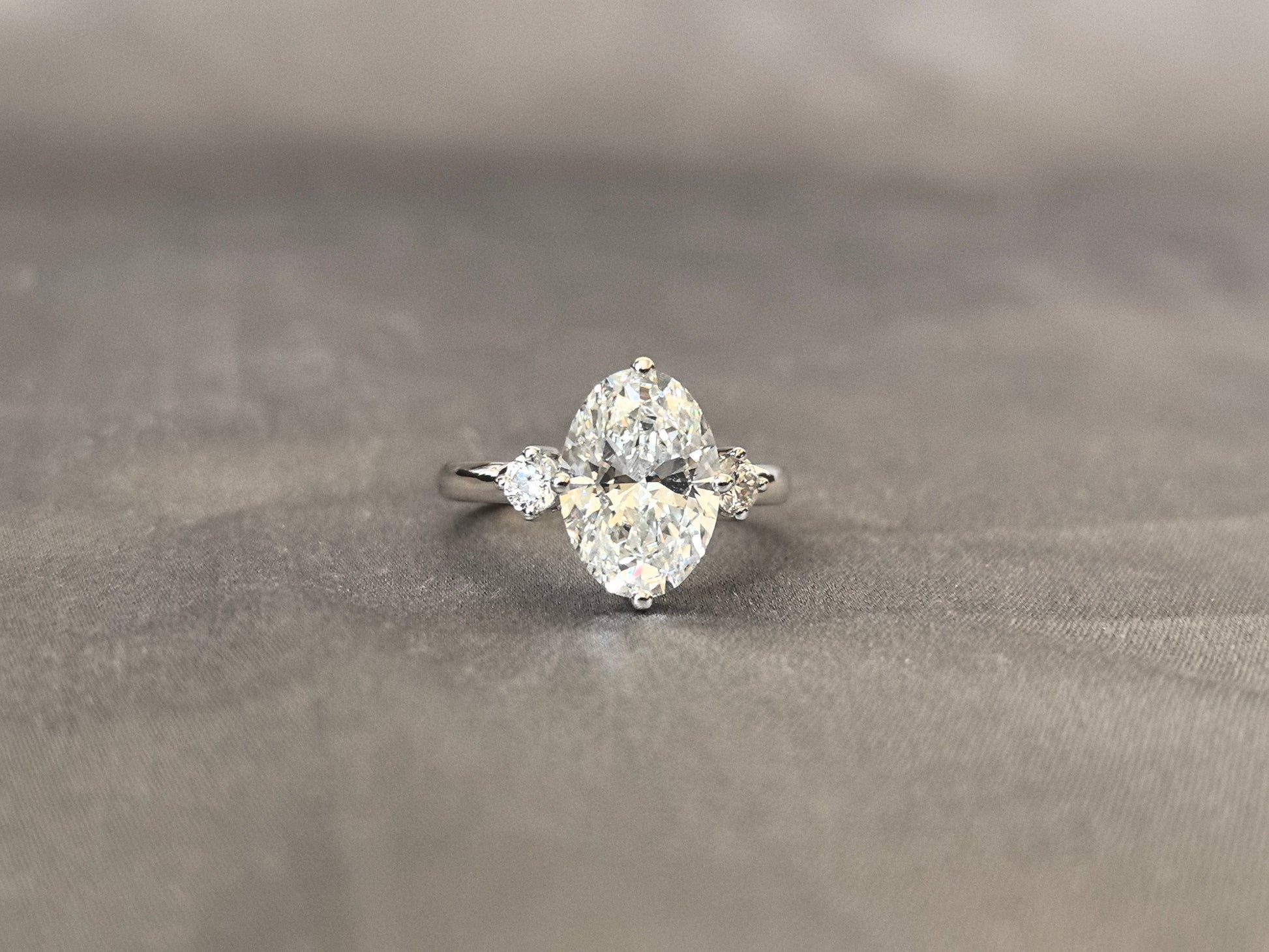 Oval Lab Diamond Three-Stone Ring - Round Side Diamonds - Four-Claw Prong Setting