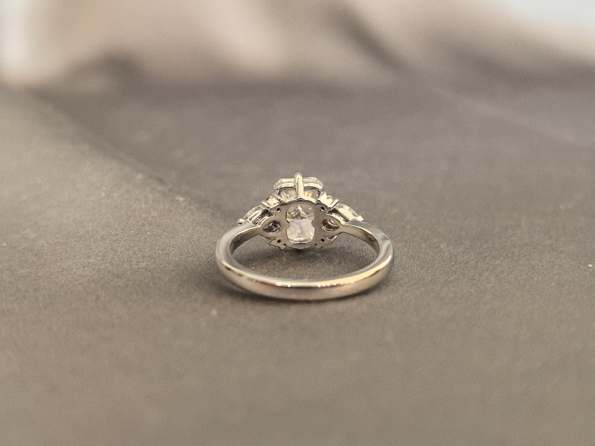 Three-stone emerald-cut lab diamond engagement ring - Pear-shaped sidestone - 4-Prong Set