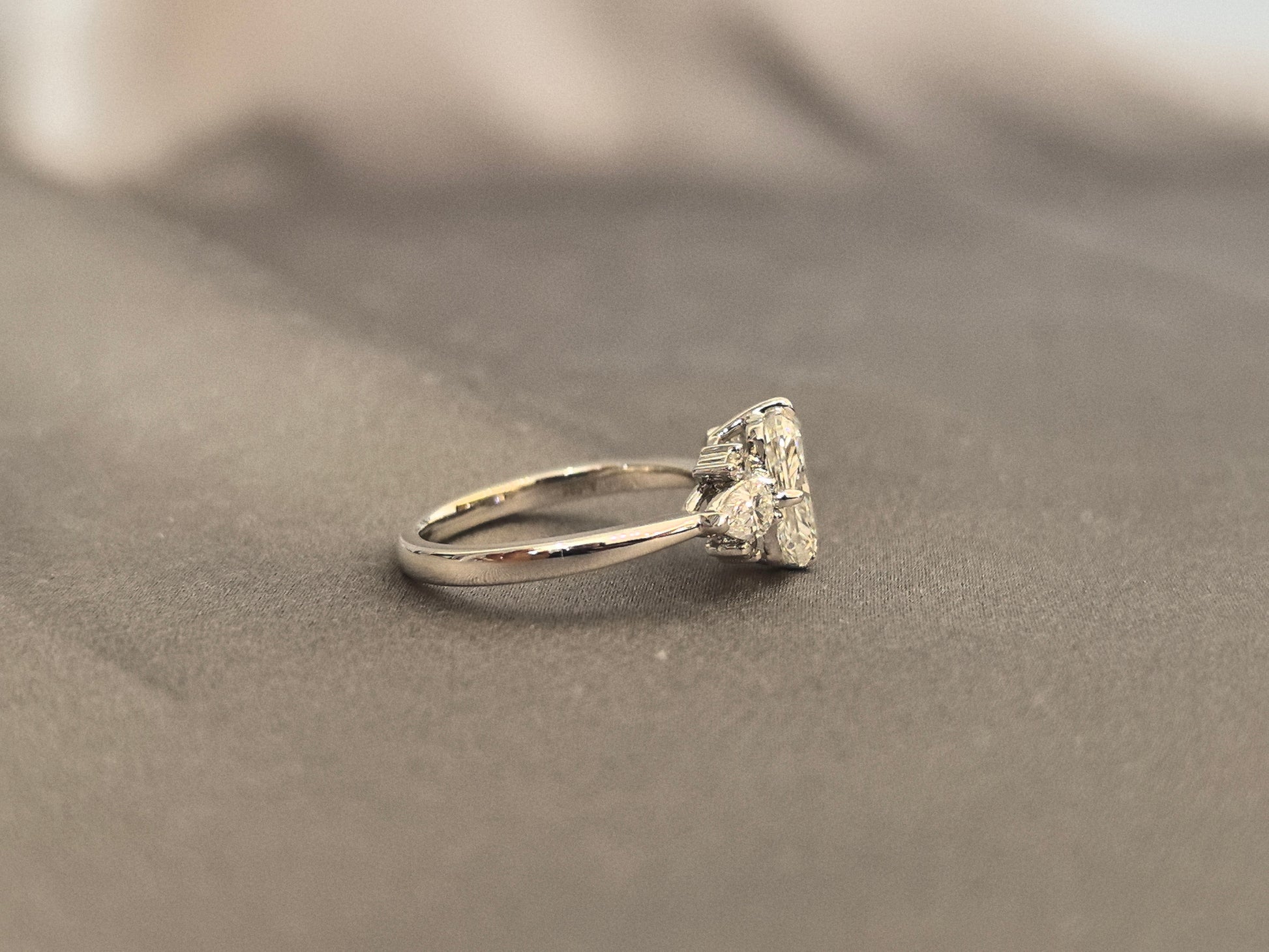 Three-stone emerald-cut lab diamond engagement ring - Pear-shaped sidestone - 4-Prong Set