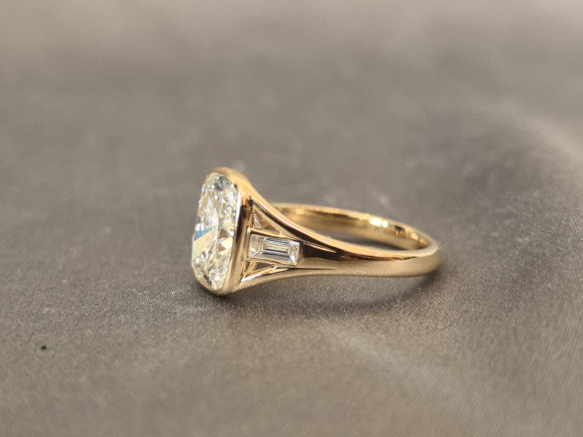 4-carat cushion cut, with emerald side stones on both sides, bezel setting, vintage design